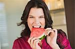 Portrait of a woman eating a slice of watermelon