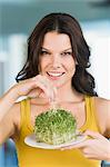 Woman eating bean sprouts and smiling