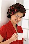 Femme tenant une tasse de café et souriant