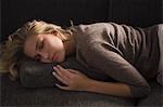 Close-up of a woman napping on a couch