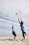 Woman with her grandson playing beach volleyball