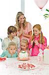 Mädchen feiern ihren Geburtstag mit ihrer Mutter und Freunde