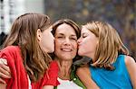 Two girls kissing their grandmother