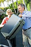 Couple loading luggage into a car