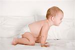 Baby girl kneeling on the bed