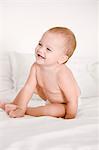 Close-up of a baby girl laughing on the bed