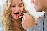 Man feeding strawberry to his wife