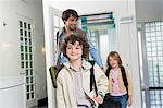 Man with his children entering a house