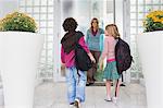 Femme avec ses enfants à la porte d'entrée d'une maison