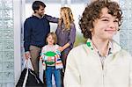 Boy smiling with his parents in the background