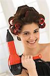 Woman holding a hair dryer and smiling