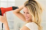 Woman drying her hair with a hair dryer