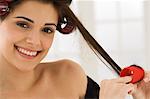 Portrait of a woman removing hair curlers