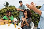 Man playing a guitar and his friends applauding him