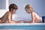 Boy with a girl playing at the poolside