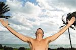 Man with his arms outstretched on the beach