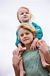 Boy carrying his sister on shoulders on the beach