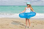 Girl wearing an inflatable ring on the beach