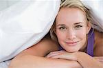 Gros plan d'une femme couchée sur le lit et souriant