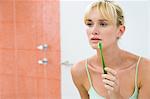 Reflexion einer Frau im Spiegel mit eine Zahnbürste