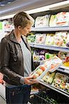 Woman buying packed food in a supermarket