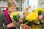 Femme tenant un bouquet de fleurs dans une boutique de fleuriste