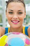 Woman holding a beach ball and smiling
