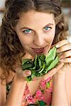 Woman smelling spinach leaves in the kitchen