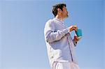 Man holding a cup of coffee on the beach