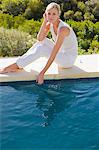 Portrait d'une femme assise au bord de la piscine