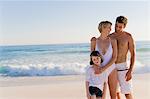 Famille se tenant debout sur la plage