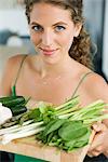 Woman holding vegetables in the kitchen