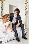 Groom consoling a desperate girl sitting on the bed covering her face