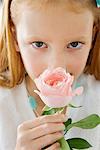 Close-up of a flower girl smelling a flower