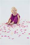 Girl sitting with flower petals scattered around her