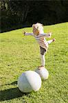 Girl balancing herself on a round stone