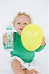 Baby Boy hält einen Ballon und einer Babyflasche