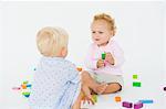 Two baby boys playing with blocks