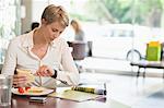 Businesswoman sitting in a restaurant and checking the time