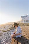 Girl sitting on a boardwalk and reading a book