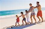 Family walking on the beach in train formation