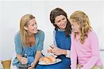 Two women preparing food with a girl at home