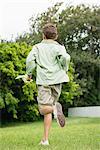 Boy running in a garden with a butterfly net