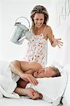 Woman waking up a man sleeping on the bed