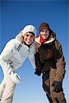 Young couple wearing ski wear, smiling at camera