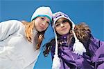 Two teenage girls in winter clothes, smiling at camera