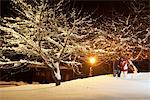 Young couple walking in snow by night