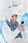 Jeune femme à l'aide du téléphone mobile dans la neige