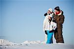 Couple and daughter in ski wear looking away