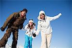 Couple and daughter in ski wear smiling at camera